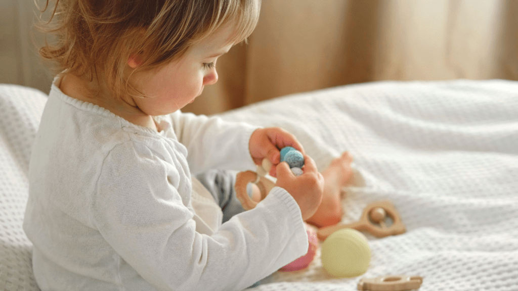 a toddler playing with toys on a bed