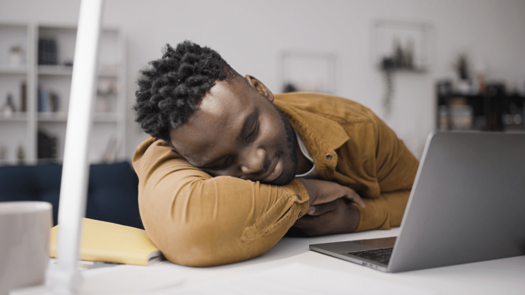 a person sleeping in front of a laptop