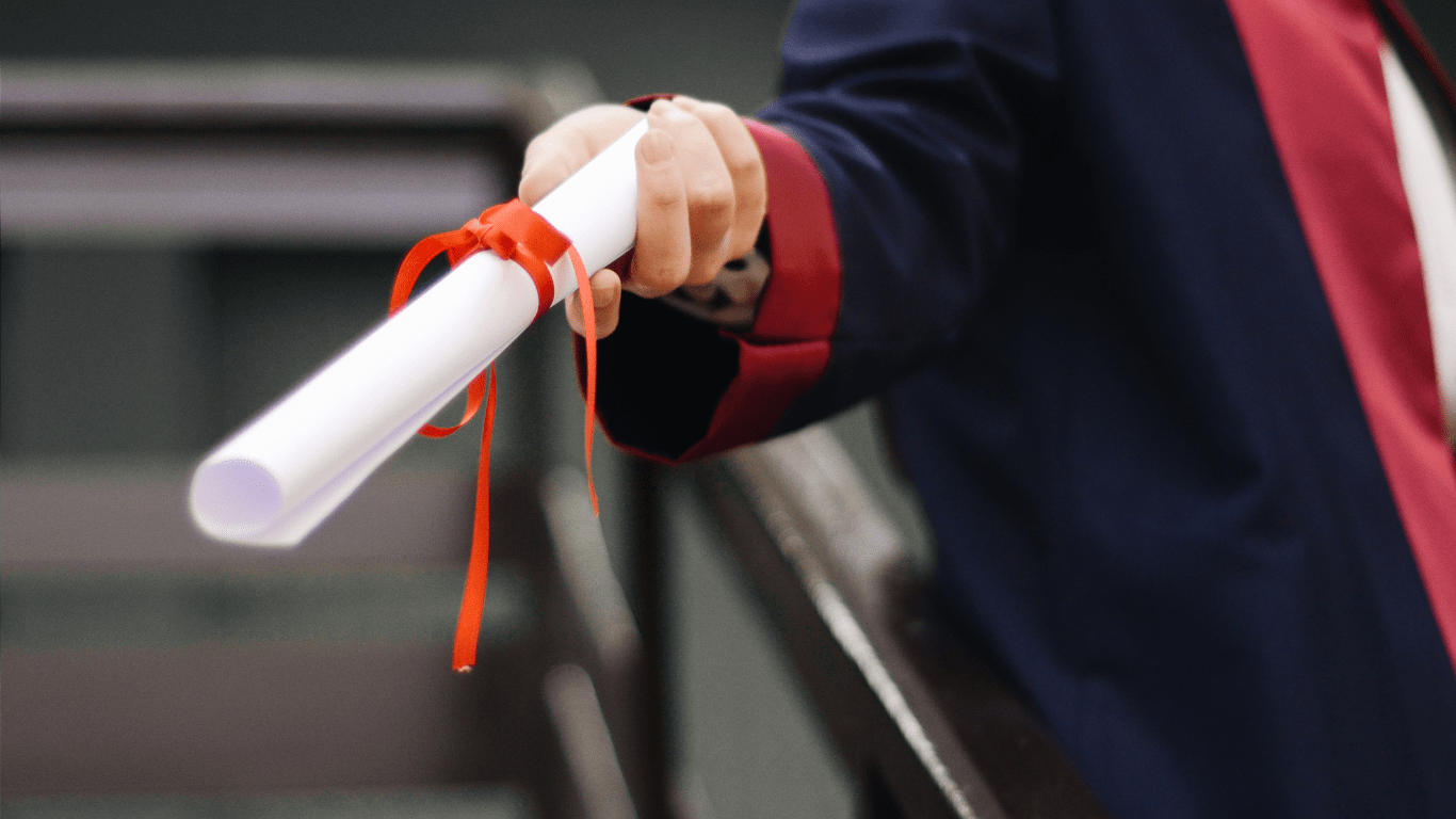 a person in a graduation gown is holding a diploma