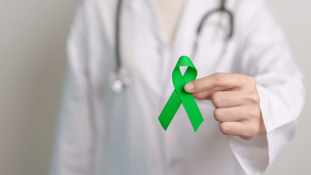 a doctor holding a green ribbon