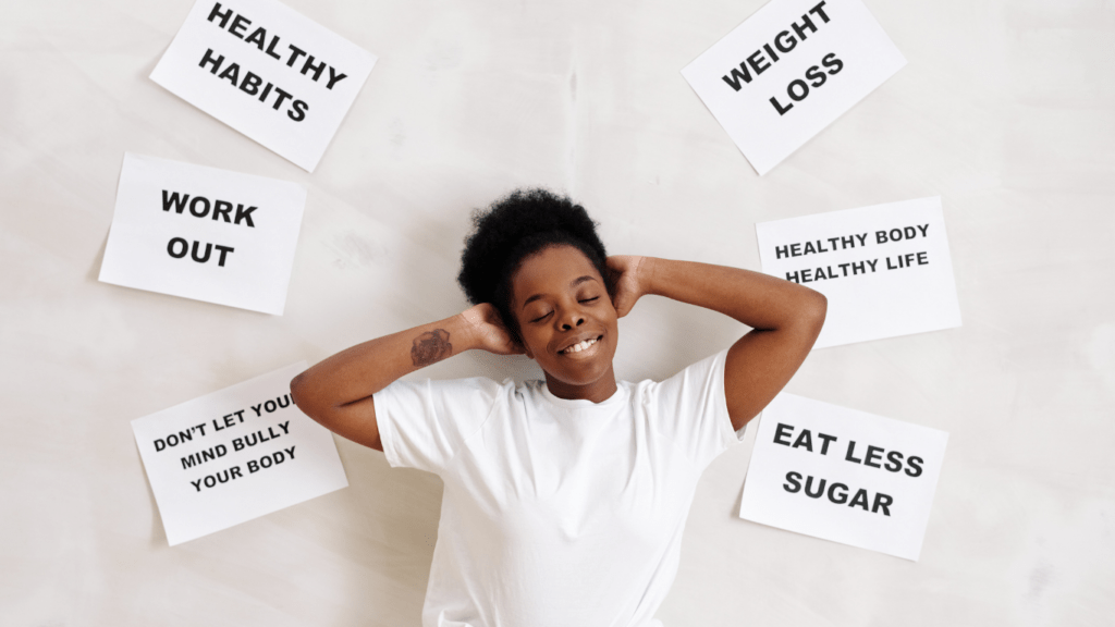 a person posing in front of a wall with a sign that says healthy habits