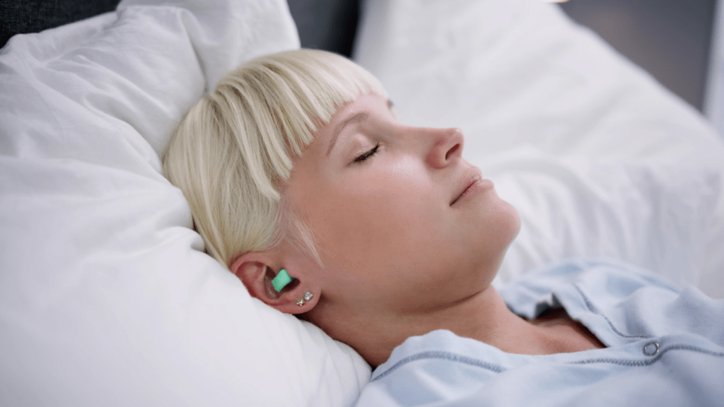 a person laying in bed with ear buds in their ears