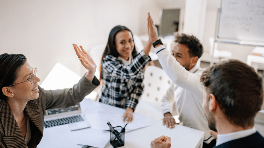 a group of people raising their hands in a meeting