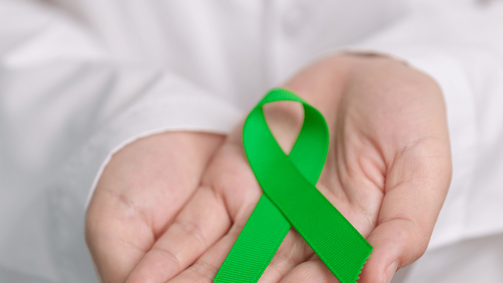 a doctor holding a green ribbon