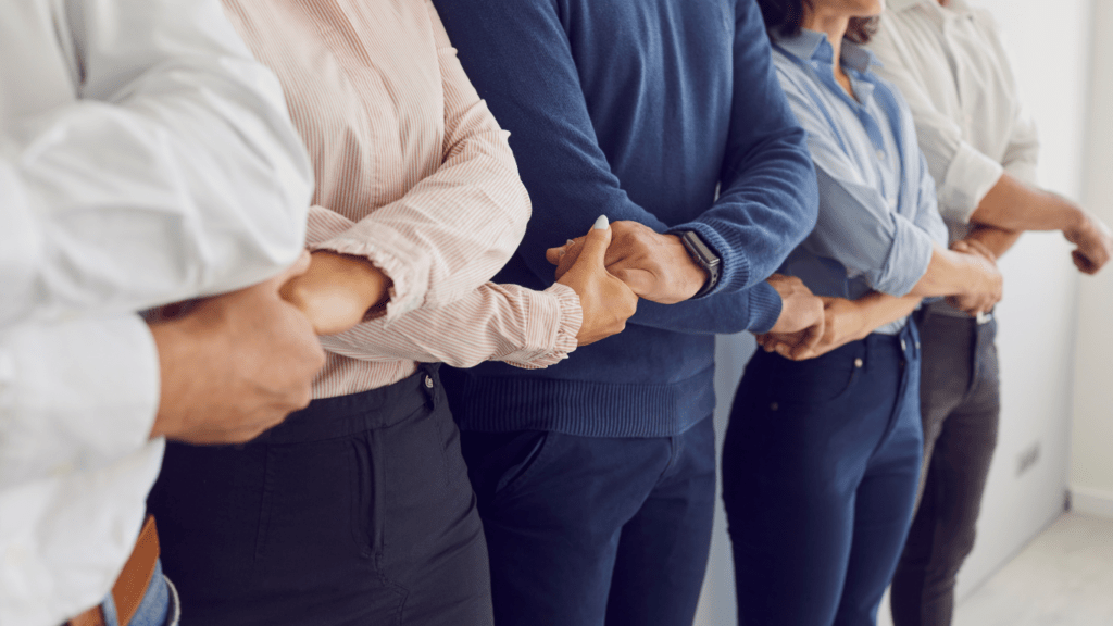 a group of business people holding hands in an office