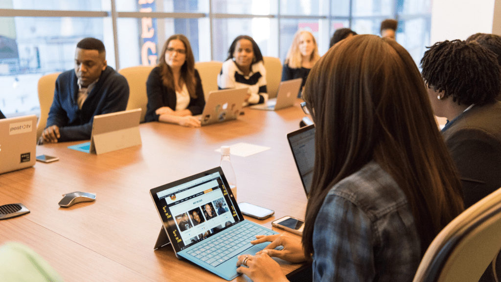 a group of people sitting at a desk in an office