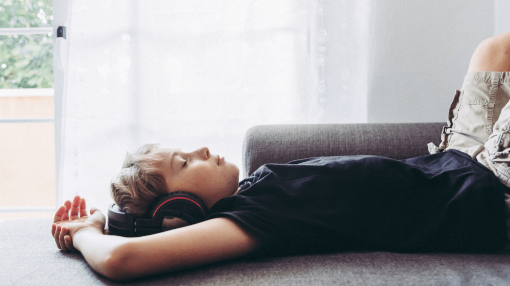 a person laying in bed with ear buds in their ears