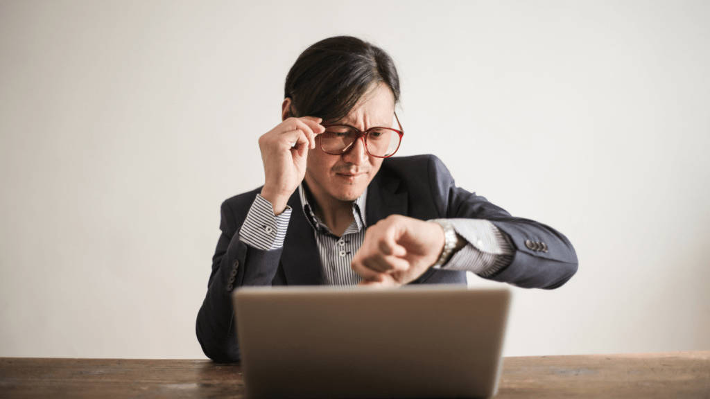 a person sitting at a desk with their hand on their wrist