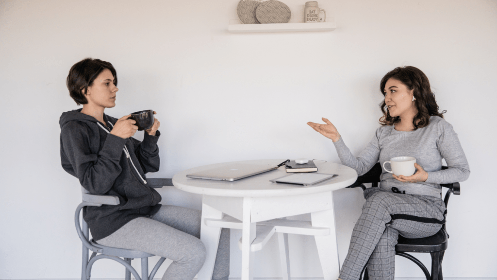 Two people sitting in chairs talking to each other