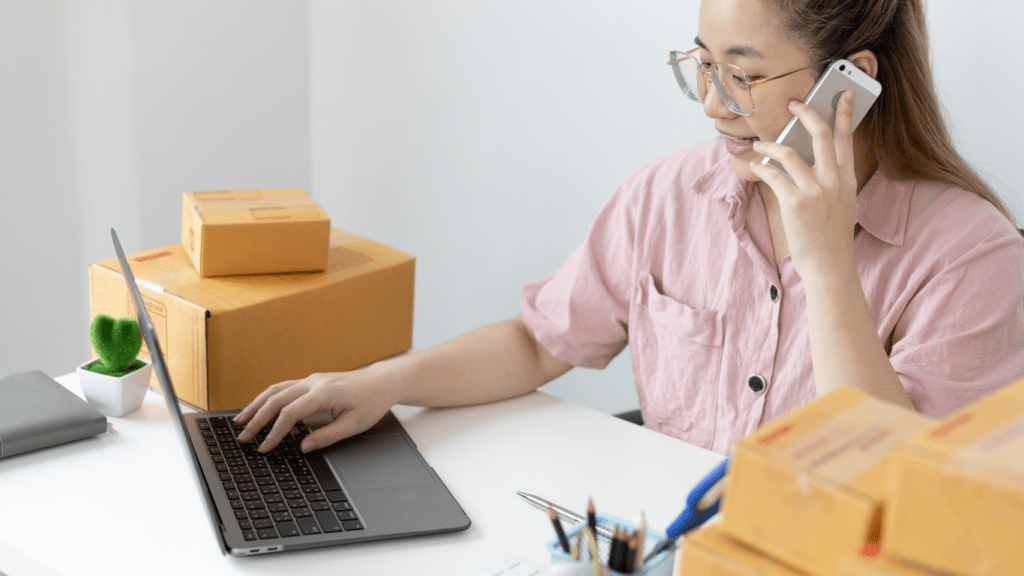 a person sitting on the floor with a laptop and boxes