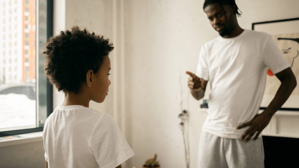 a person talking to a young person in a living room