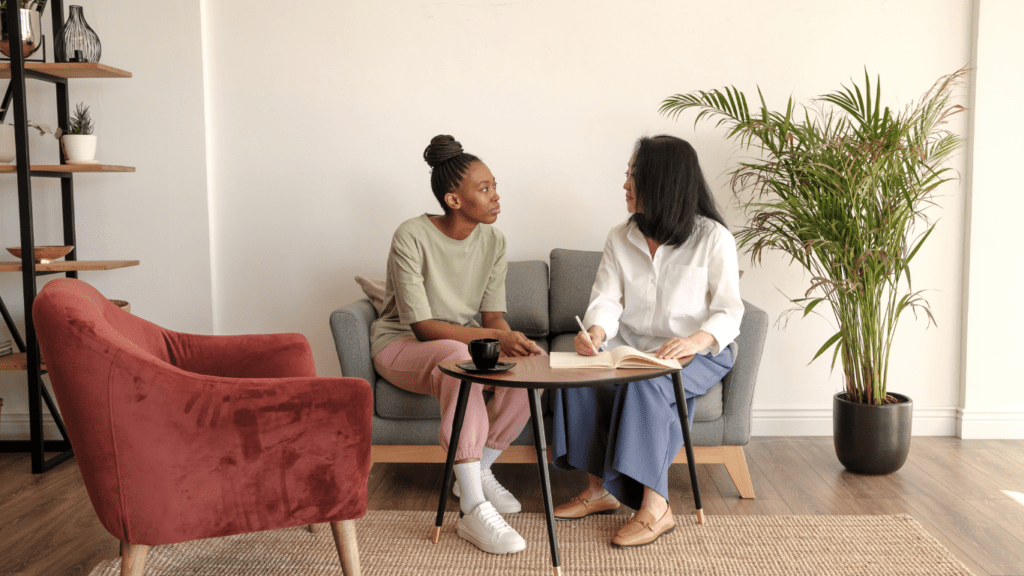 two people sitting on a couch talking to each other