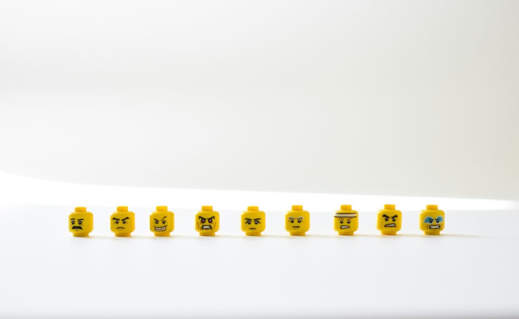 Heads of LEGO figurines lined up on a white surface.